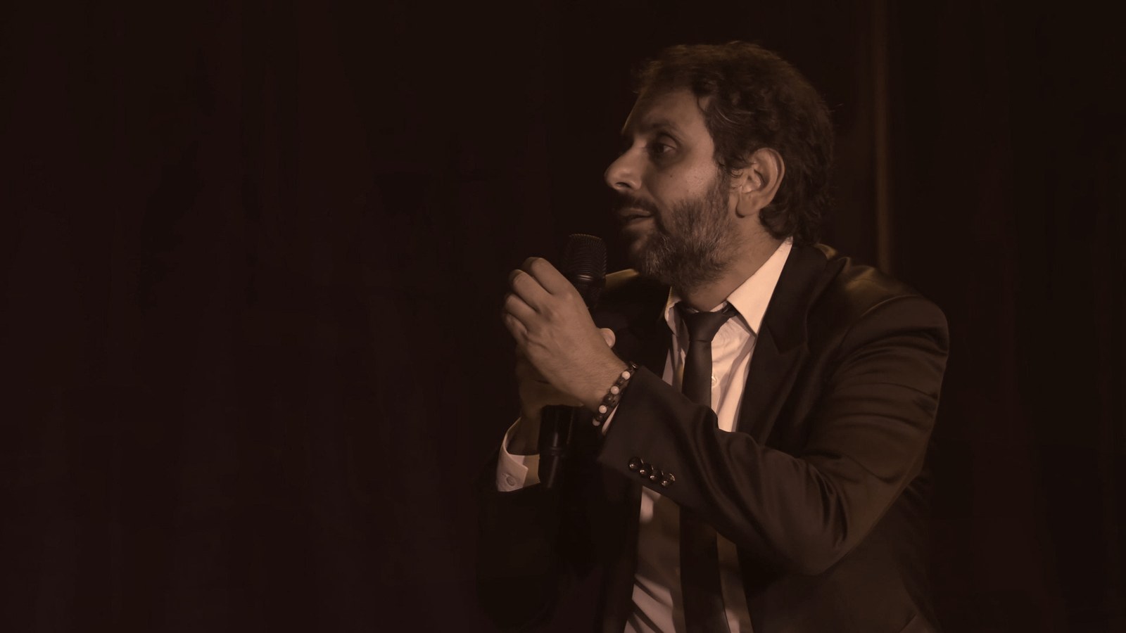 François Anto de profil, micro à la main