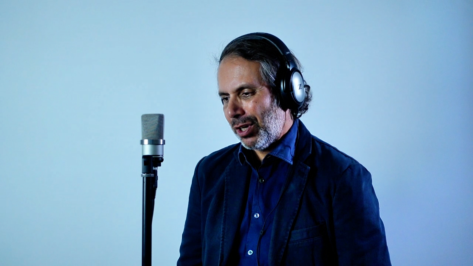 François Anto au micro, casque sur les oreilles, pendant l’enregistrement en studio