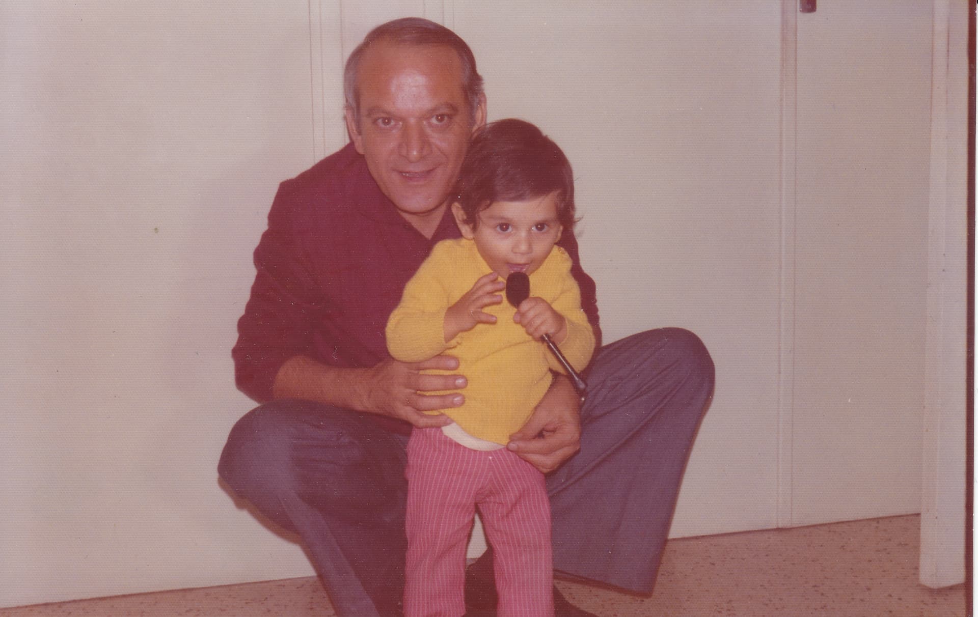 Photographie ancienne : François Anto enfant, la pipe de son grand-père en guise de micro à la main, avec son père